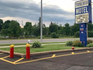 a motel sign in a parking lot next to a road at Trunk Road Motel in Sault Ste. Marie +40 photos