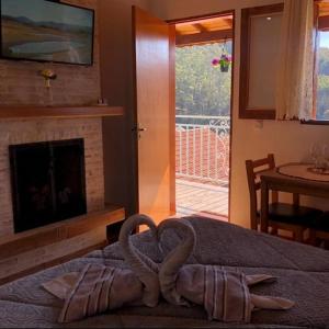 a room with a bed with two swans on it at Recanto lavinia in Monte Verde +68 photos