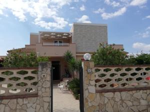 a house with a stone fence in front of it at Casa Veronica in Marzamemi