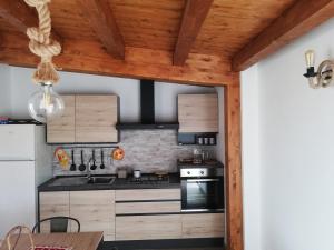 een keuken met houten plafonds en een fornuis met oven bij Casa Veronica in Marzamemi
