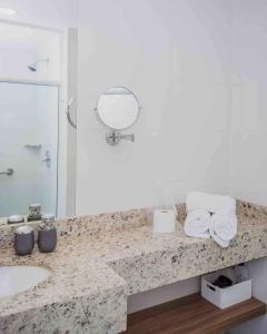 a bathroom with a counter with a sink and a mirror at Flat Completo para uma estadia perfeita NOTA FISCAL in Campos dos Goytacazes