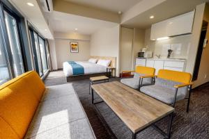京都RESI STAY Heart的酒店客房,配有一张床和两把椅子