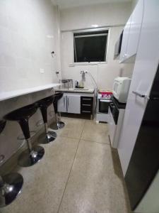 een kleine keuken met 2 aanrechtbladen en een wastafel bij Apartamento mobiliado prédio frente ao mar in São Vicente