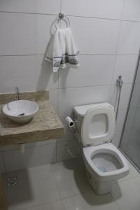 a bathroom with a white toilet and a sink at Casa temporada nascentes do jalapao in Mateiros