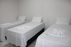 two beds with white sheets and towels on them at Casa temporada nascentes do jalapao in Mateiros