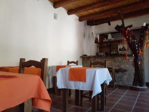 a room with two tables and a fireplace at La Casa de Violeta in Tilcara