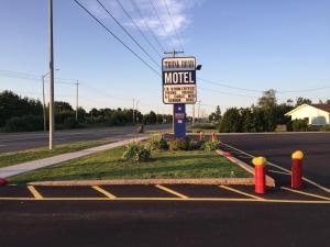 a motel sign sitting on the side of a road at Trunk Road Motel in Sault Ste. Marie