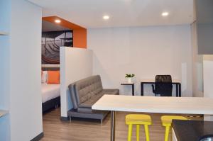 Habitación con mesa, sillas y cama en Suites Home 118 By SHG, en Bogotá