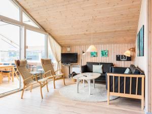a living room with a couch and chairs and a table at 4 person holiday home in Henne in Henne Strand