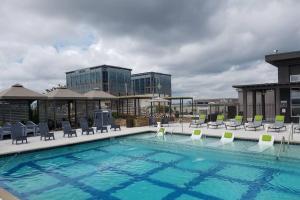 a large swimming pool with chairs and a building at Buckhead Blue - Spacious 2 bd 2ba - Private Balcony-Rooftop- S13 in Atlanta