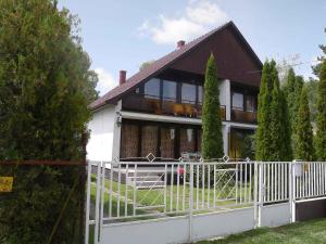 een huis met een wit hek ervoor bij Holiday home in Szantod/Balaton 20220 in Szántód