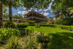 a house with a garden in front of it at Casa Las Palmas, San Miguel de Allende in San Miguel de Allende