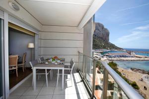 een balkon met een tafel en uitzicht op het strand bij Apartamento Paradero de Ifach - Costa CarpeDiem in Calpe