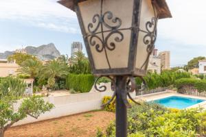 un lampadaire devant une piscine dans l'établissement Villa Caleta - Costa CarpeDiem, à Calp