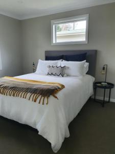 a bedroom with a large white bed with a window at Outback on Broadway in Picton