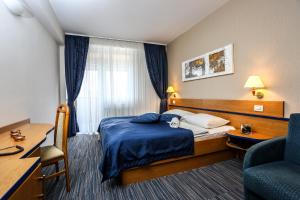 a hotel room with a bed and a desk and a chair at Hotel Dražica - Hotel Resort Dražica in Krk