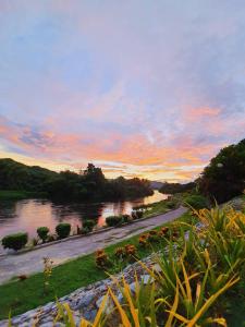 Aekpailin River Kwai Resort في مدينة كانشانابوري: اطلاله على نهر وقت الغروب