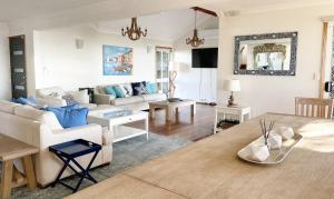 uma sala de estar com um sofá e uma mesa em Ocean Pearl - 3 bedroom beachfront property! em Beachmere