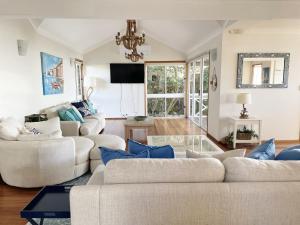 uma sala de estar com dois sofás e um lustre em Ocean Pearl - 3 bedroom beachfront property! em Beachmere