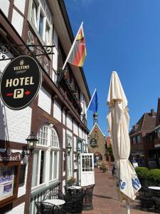 una señal de hotel y una sombrilla fuera de un edificio en Hotel Hagspihl en Quakenbrück