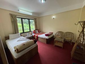 Habitación de hotel con 2 camas y ventana en Hotel Nagarkot Holiday Inn en Nagarkot