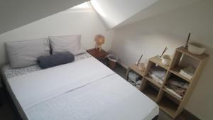 um pequeno quarto com uma cama branca e uma prateleira em CHILL SPOT avec vue sur lagon - with a lagoon view SXM em Marigot