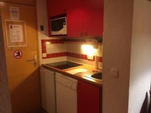 Plagne 1800にあるAppartement Plagne 1800, 2 pièces, 4 personnes - FR-1-351-92の小さなキッチン(赤いキャビネット、シンク付)
