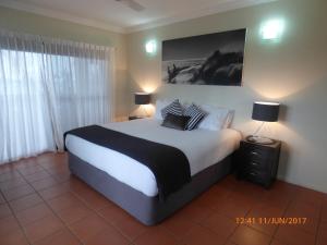 a bedroom with a large bed with two lamps on it at Compass Point 8 in Hamilton Island