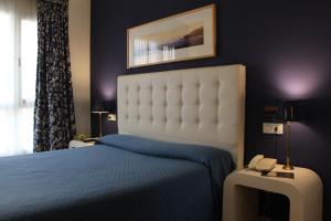 リバデオにあるオテル ボウサのベッドルーム1室(ベッド1台、テーブル上の電話付)