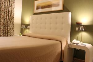 una habitación de hotel con una cama y un teléfono en una mesa en Hotel Bouza en Ribadeo