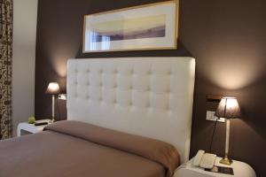 1 dormitorio con 1 cama y una foto en la pared en Hotel Bouza, en Ribadeo