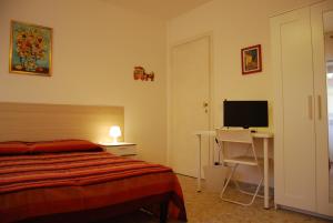 Un dormitorio con una cama y un escritorio con televisión. en Residenza Flaminia, en Roma