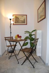 una mesa y una silla con una planta en una habitación en Residenza Flaminia, en Roma