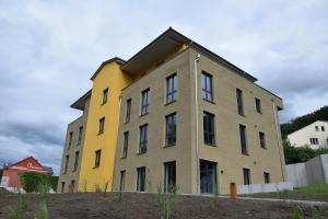 um edifício amarelo e cinzento sentado em cima de um campo em Prinzess Brunhilde - Appartementhaus em Thale