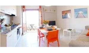 cocina y sala de estar con mesa y sillas en siciliacasevacanze - Villa Venere, en Marina di Ragusa