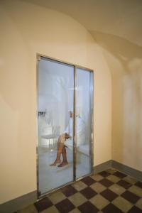 a woman sitting in a glass door in a room at Regina Bianca - Camere, Suite & Spa - Sciacca in Sciacca +37 photos