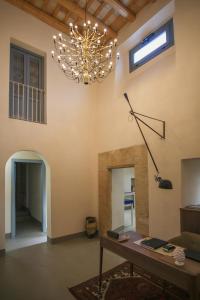 a living room with a table and a chandelier at Regina Bianca - Camere, Suite & Spa - Sciacca in Sciacca