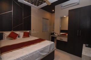 ein Schlafzimmer mit einem großen Bett und einem Waschbecken in der Unterkunft Hotel Atlantis in Kumbakonam