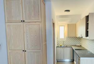 a kitchen with wooden cabinets and a counter top at sun studios in Mikonos