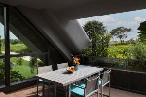 a table and chairs on the balcony of a house at Dusit Thani Laguna Singapore in Singapore