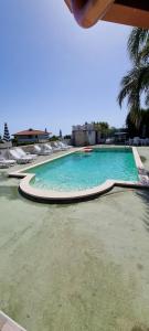 une grande piscine avec des chaises longues dans un complexe dans l'établissement Villa Maria con piscina e giardino privato, à Santa Maria