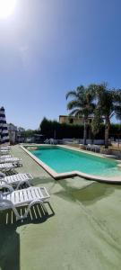 - une piscine avec des chaises longues et des palmiers dans l'établissement Villa Maria con piscina e giardino privato, à Santa Maria