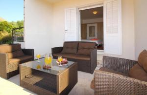 d'une terrasse avec des chaises en osier et une table avec des boissons. dans l'établissement Apartments Dubreta, à Cavtat