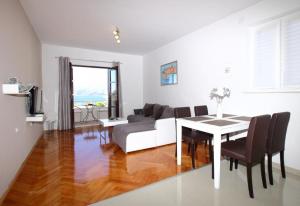 a living room with a table and a couch at Apartments Dubreta in Cavtat