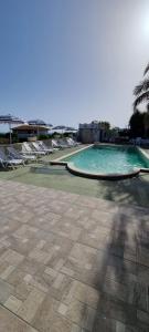 une piscine vide avec des chaises et l'océan dans l'établissement Villa Maria con piscina e giardino privato, à Santa Maria