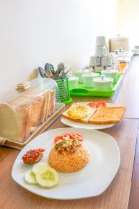安汶LeGreen Suite Ratulangi的桌子上有三盘食物
