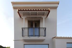 a white building with a balcony at Sivota Apartment in Syvota