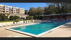 una grande piscina con sedie e un edificio di Apartamento Francelos Condominio a Vila Nova de Gaia