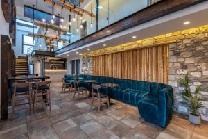 a lobby with a green couch and tables and chairs at NISSEA Boutique Hotel in Kardamaina