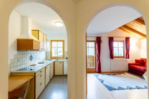 a kitchen with an archway leading to a living room at Villa Anna in Siusi